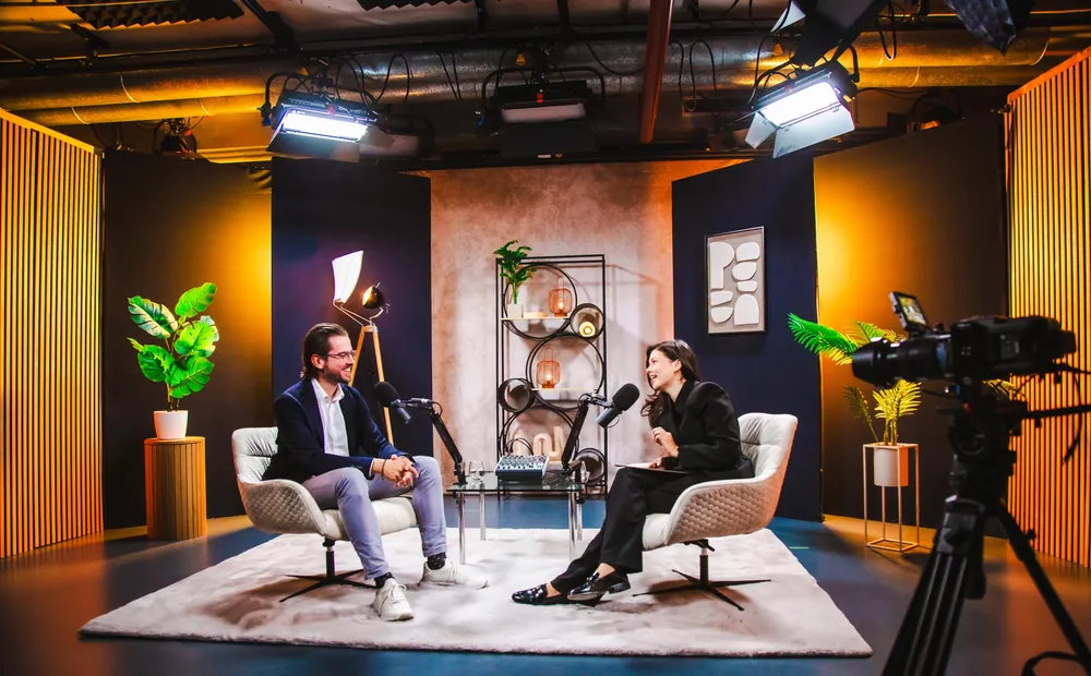 Podcast-Set im Content Club Studio mit zwei Loungesesseln, Teppich und Deckenlicht