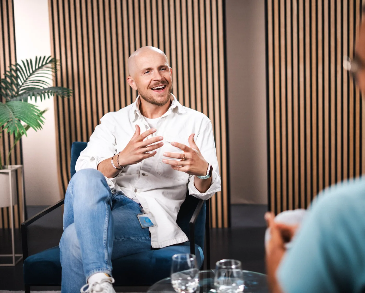 Dominik Wasik im Gespräch, lachend und mit lebhafter Gestik in einem Sessel